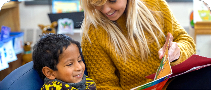 Kindergarten students reading with an educator
