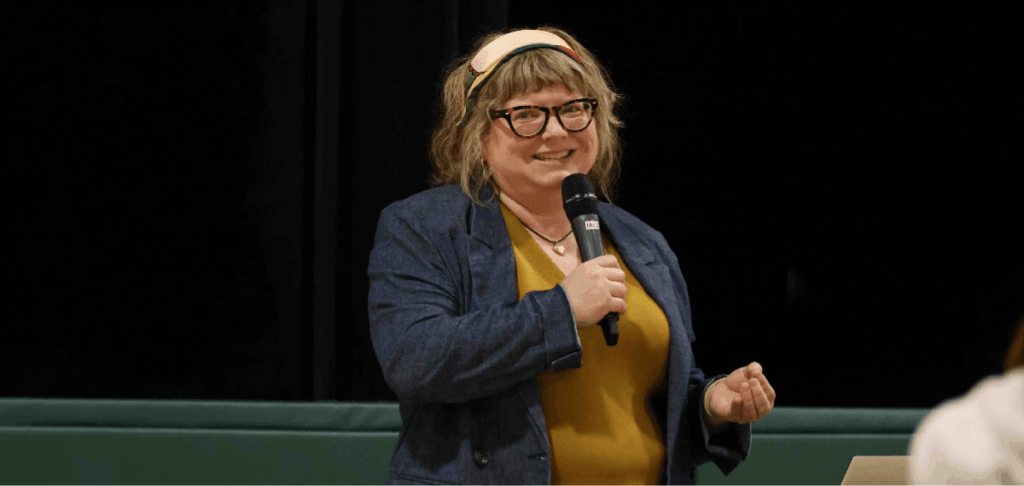 Presenter speaking into a microphone during an information session.